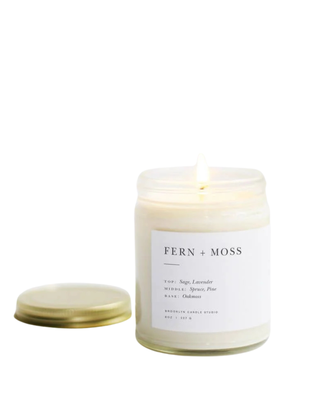 Fern + Moss candle in a clear glass jar with a minimalist label, featuring sage, lavender, spruce, and pine fragrance oils for a natural, outdoors-inspired scent. by Brooklyn Candle Studio
