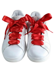 Cherry red satin sneaker laces styled on a pair of white Stan Smith sneakers